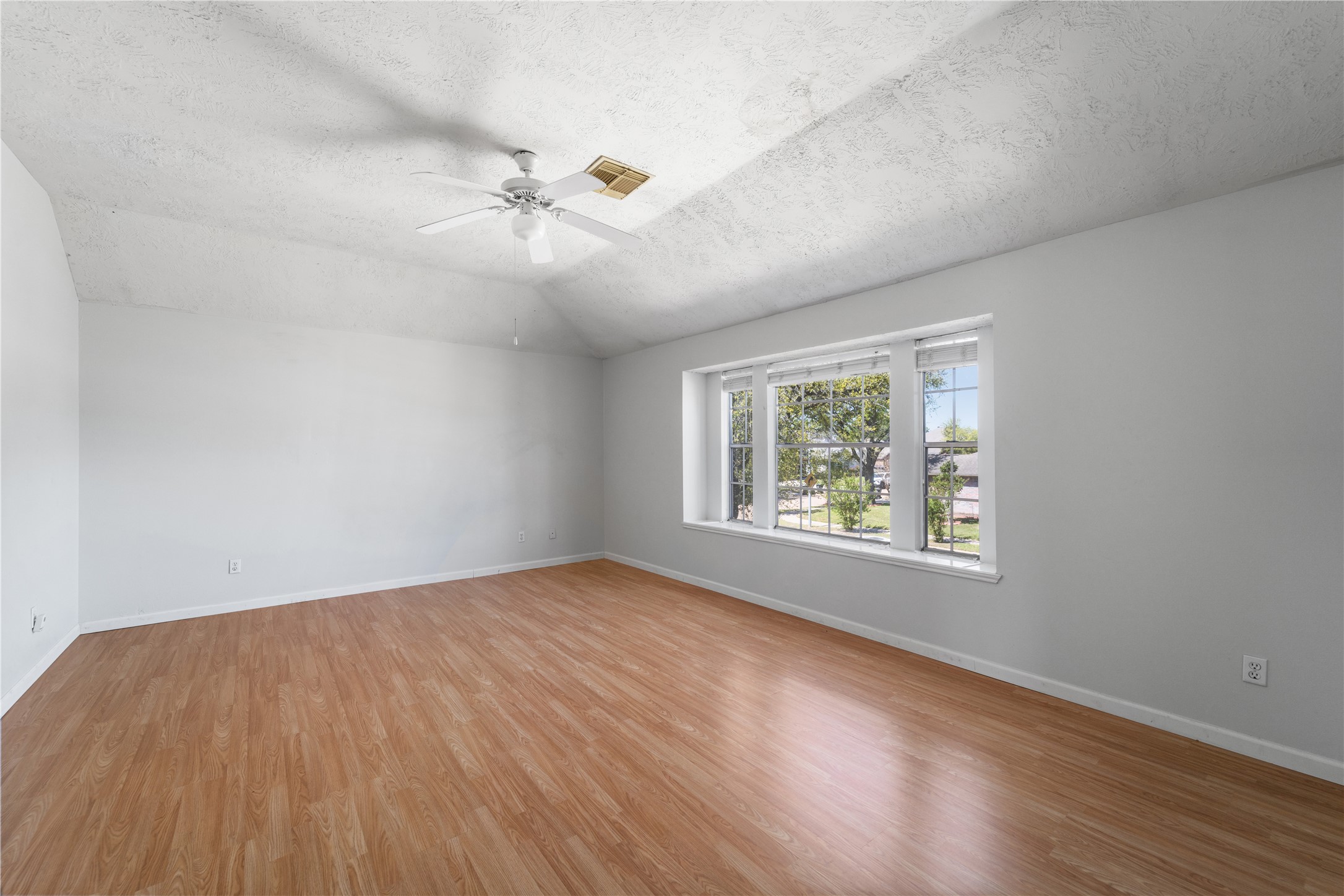 11959 Swords Creek Road Houston, TX 77067 - Photo 24 of 30 an empty room with wooden floor ceiling fan and windows