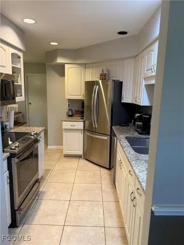 a kitchen with a sink a stove top oven a counter space and cabinets