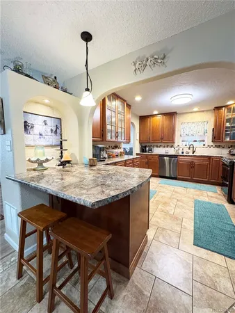 a kitchen with stainless steel appliances granite countertop a stove and a refrigerator