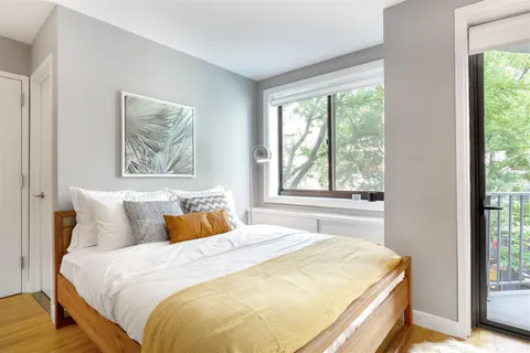 a bedroom with a bed and wooden floor