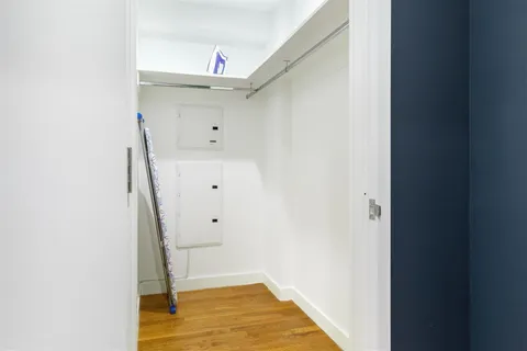 a view of walk in closet with wooden floor