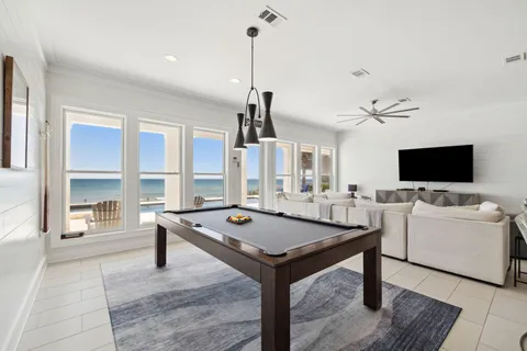 a living room with furniture a flat screen tv and a large window