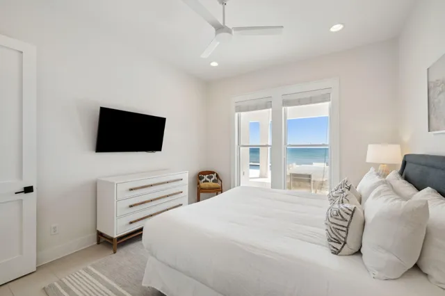 a bedroom with a bed and a flat tv screen on wall