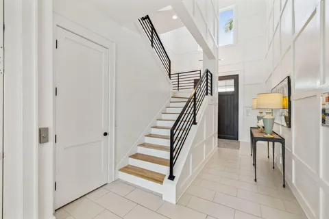 a view of a hallway with wooden floor and a bathroom