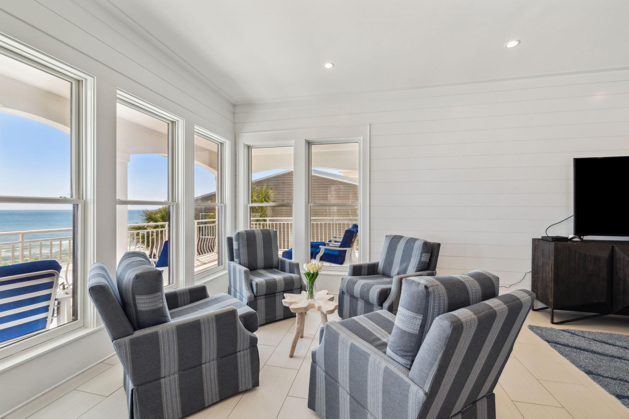 8266 East County Highway 30A Seacrest, FL 32461 - Photo 72 of 148 a living room with furniture a flat screen tv and a floor to ceiling window