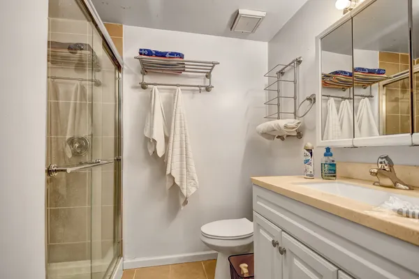 a bathroom with a sink a toilet and shower