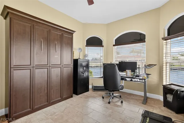 a view of a workspace with furniture and a window