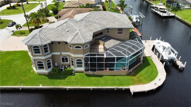 an aerial view of a house with a garden and lake view