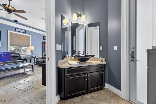 a en suite bathroom with a granite countertop sink and a mirror