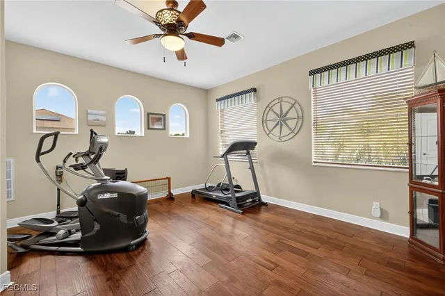 a room with gym equipment and wooden floor