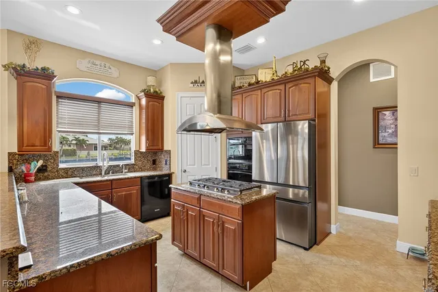 a kitchen with stainless steel appliances granite countertop a refrigerator a stove and a sink