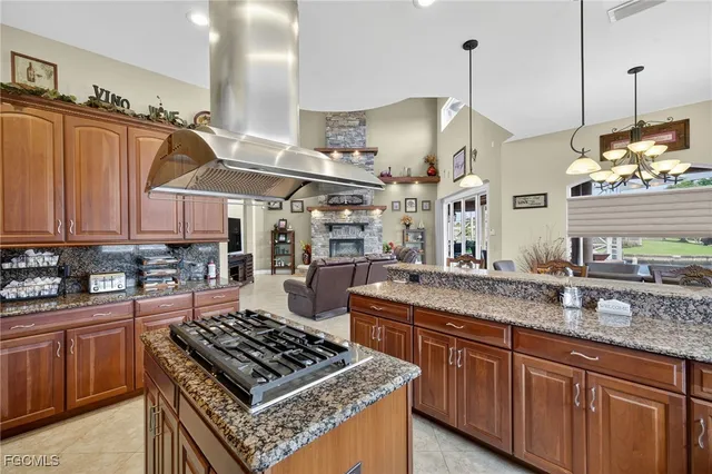 a kitchen with stainless steel appliances granite countertop a sink a stove and a wooden floors