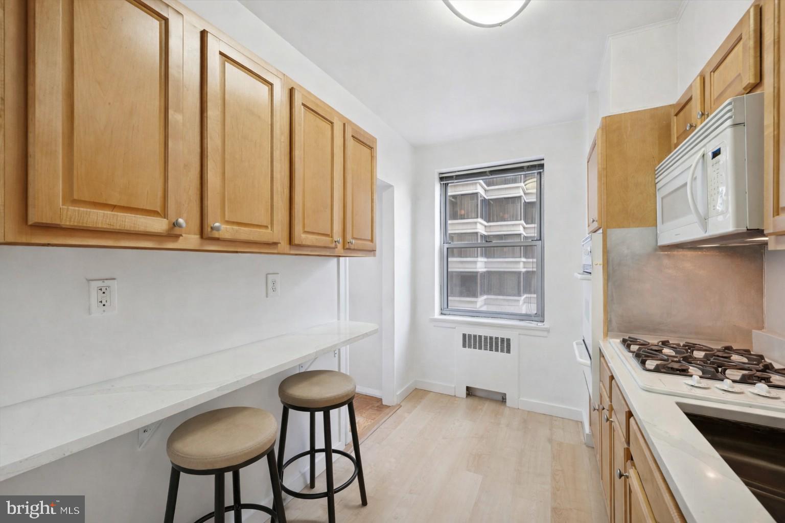 220 West Rittenhouse Square, Unit 6F Philadelphia, PA 19103 - Photo 17 of 26 a kitchen with stainless steel appliances granite countertop a stove a sink and a refrigerator with wooden cabinets