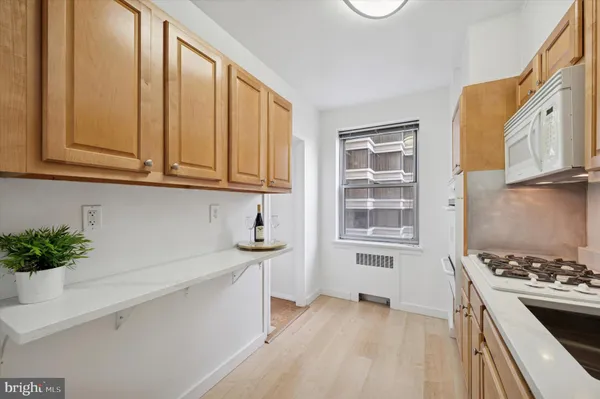a kitchen with stainless steel appliances granite countertop a stove and a white cabinets