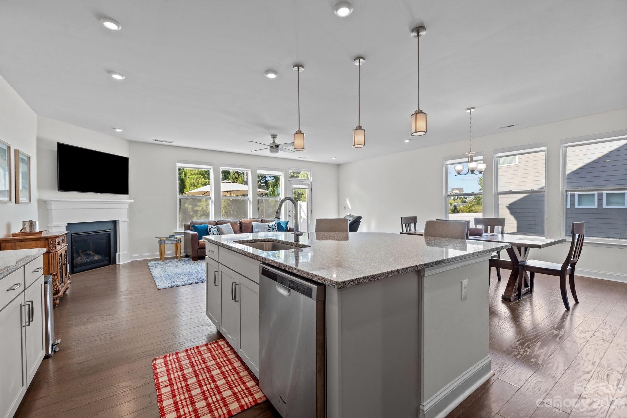 2075 Suttonview Road Fort Mill, SC 29708 - Photo 6 of 39 a open kitchen with stainless steel appliances granite countertop a stove top oven a sink dishwasher a dining table and chairs with wooden floor