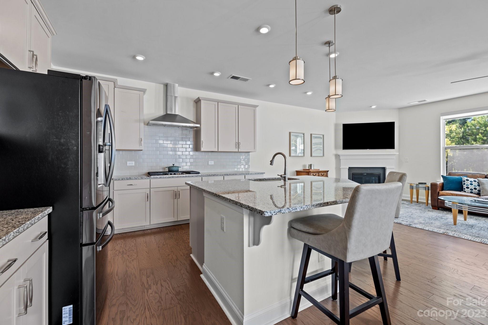 2075 Suttonview Road Fort Mill, SC 29708 - Photo 7 of 39 a kitchen with stainless steel appliances granite countertop a stove top oven a refrigerator a sink and a dining table with wooden floor