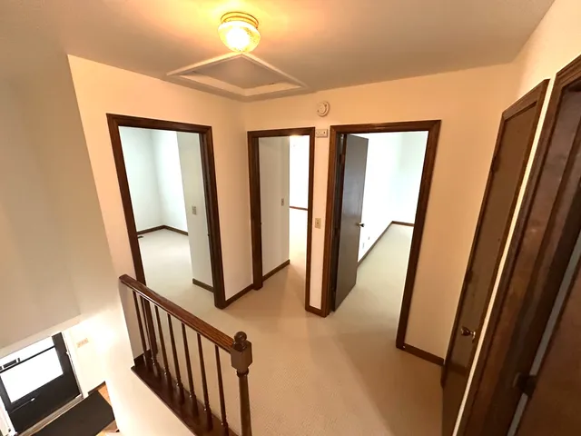 a view of a hallway with wooden floor and staircase