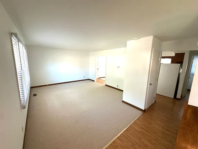 an empty room with wooden floor and entrance