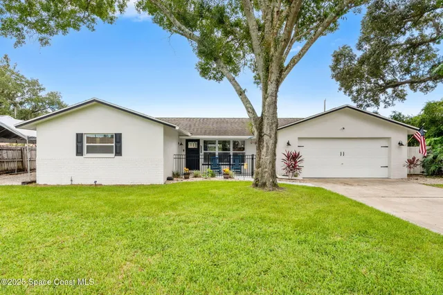 a white house that has a tree in front of it