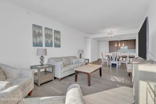a living room with furniture and a view of kitchen