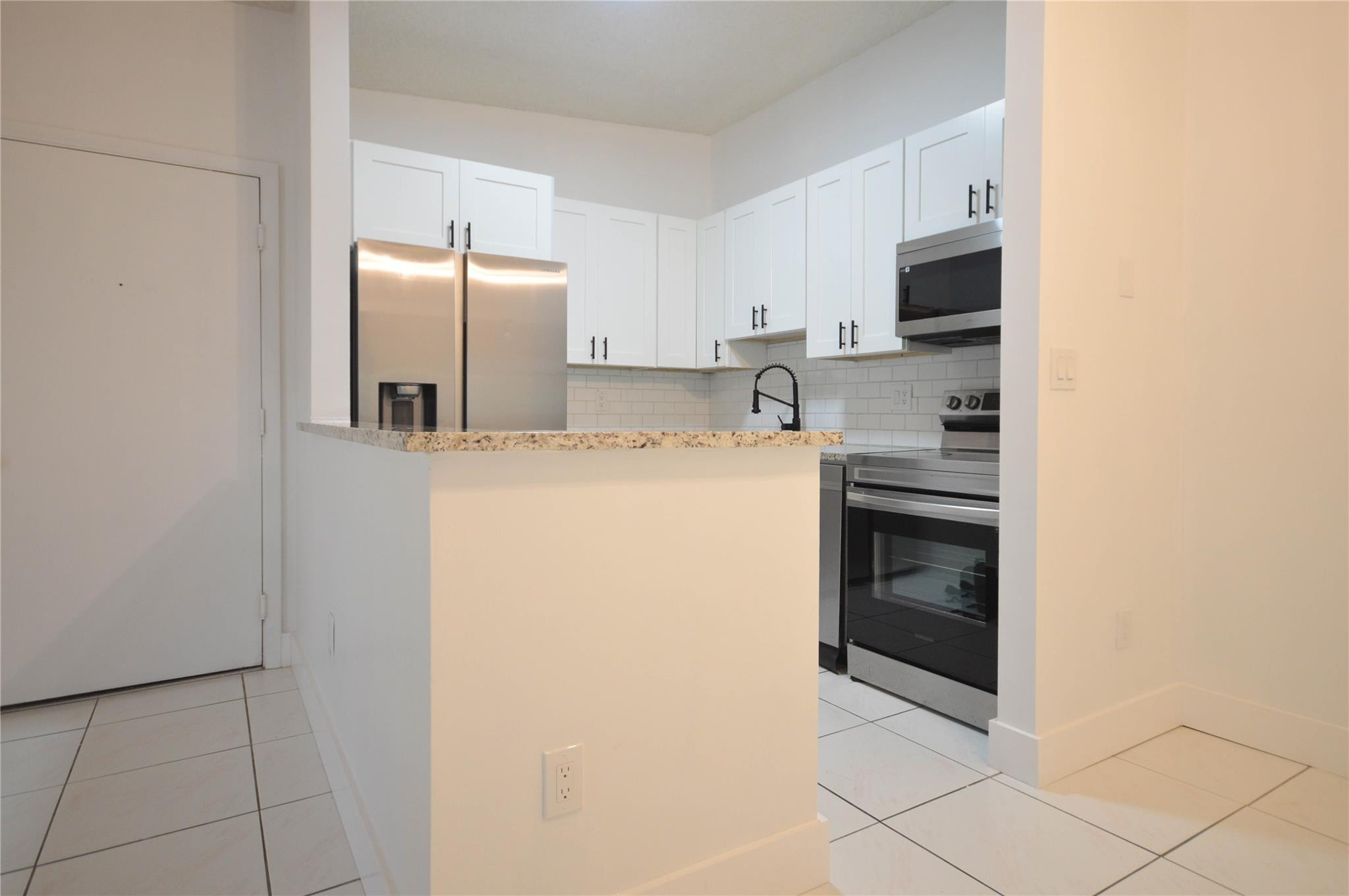 9499 West McNab Road, Unit 208 Tamarac, FL 33321 - Photo 3 of 19 a kitchen with cabinets and stainless steel appliances