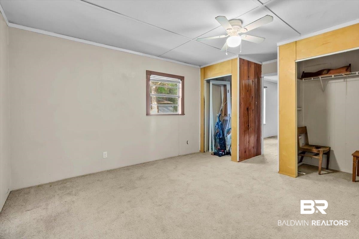 4918 Quimby Drive Mobile, AL 36619 - Photo 24 of 38 Unfurnished bedroom featuring carpet, crown molding, ceiling fan, and multiple closets