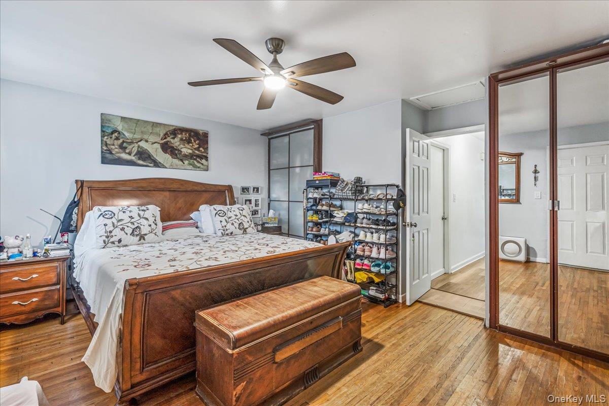 132-14 Horace Harding Expressway Queens, NY 11367 - Photo 16 of 25 Bedroom featuring hardwood / wood-style flooring, attic access, and a ceiling fan