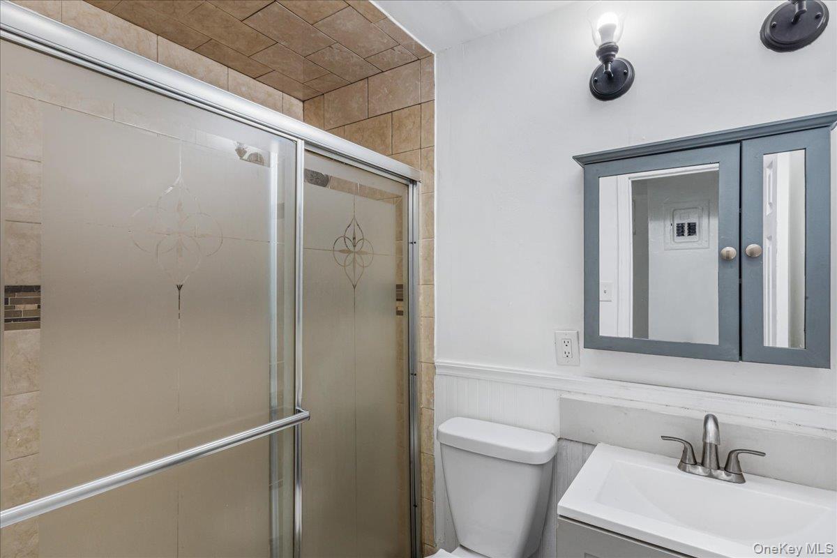 132-14 Horace Harding Expressway Queens, NY 11367 - Photo 7 of 25 Full bath with vanity, a stall shower, and a wainscoted wall