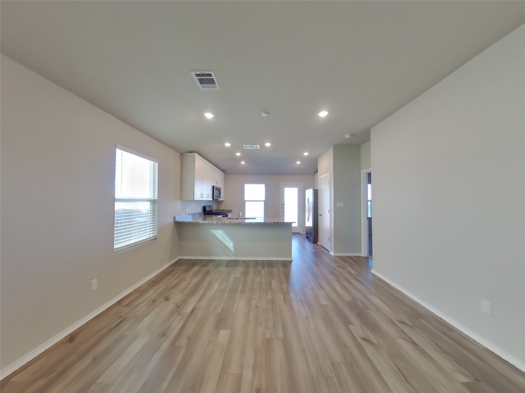 5205 Sidesaddle Drive Georgetown, TX 78626 - Photo 25 of 26 Kitchen featuring white cabinets, a peninsula, open floor plan, recessed lighting, and dark wood finished floors