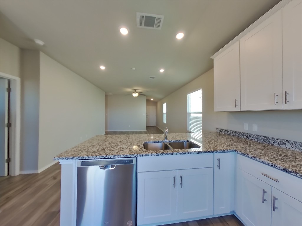 5205 Sidesaddle Drive Georgetown, TX 78626 - Photo 3 of 26 Kitchen featuring a peninsula, white cabinets, dishwasher, light stone countertops, and recessed lighting