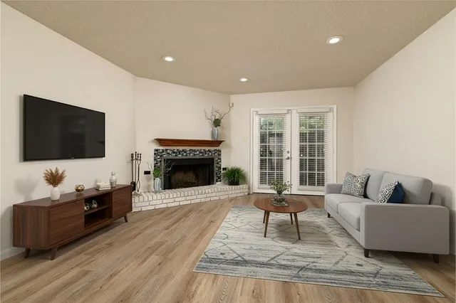 a living room with furniture a flat screen tv and a fireplace