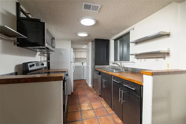 a kitchen with stainless steel appliances granite countertop a sink stove and refrigerator
