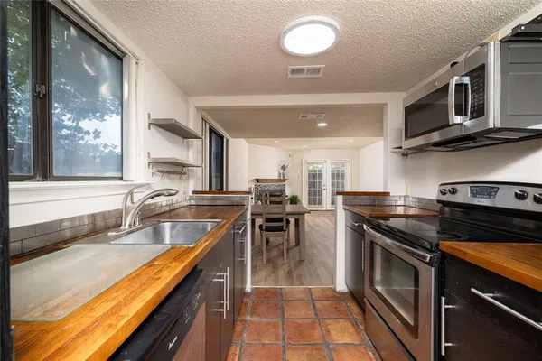 a kitchen with stainless steel appliances granite countertop a stove a sink and a microwave