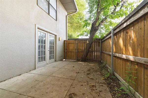a view of backyard with wooden fence and large trees