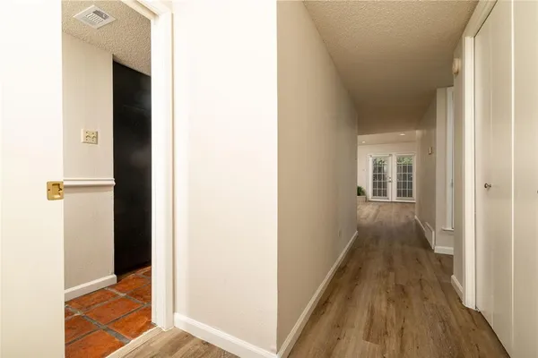 a view of a hallway with wooden floor