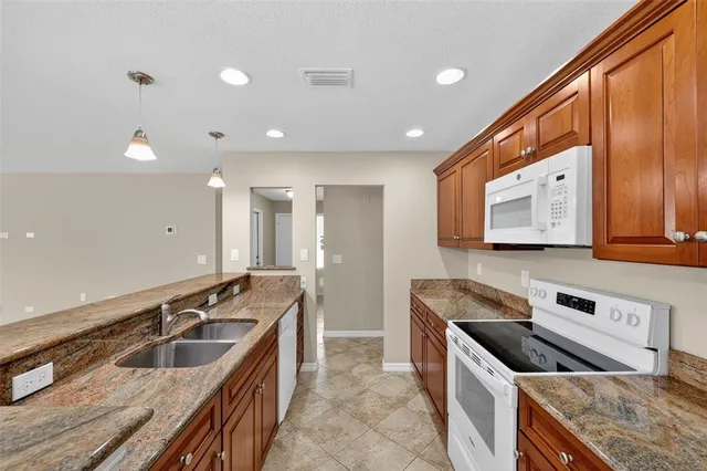 a kitchen with stainless steel appliances granite countertop a sink and a stove