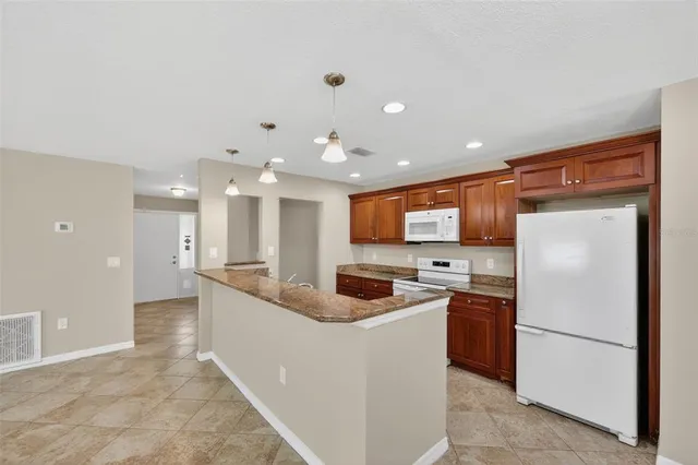 a kitchen with stainless steel appliances granite countertop a refrigerator sink and cabinets