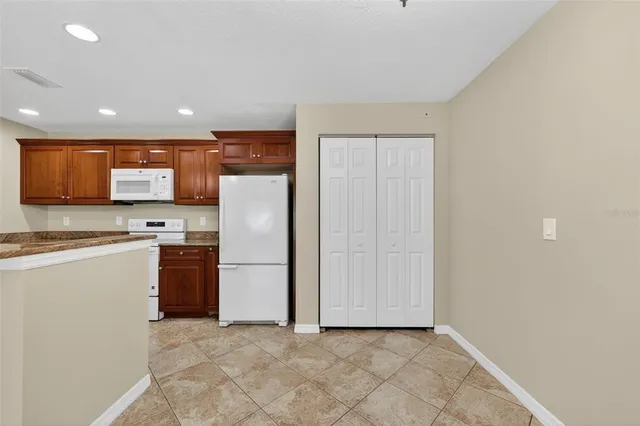 a kitchen with stainless steel appliances granite countertop a refrigerator and a stove top oven
