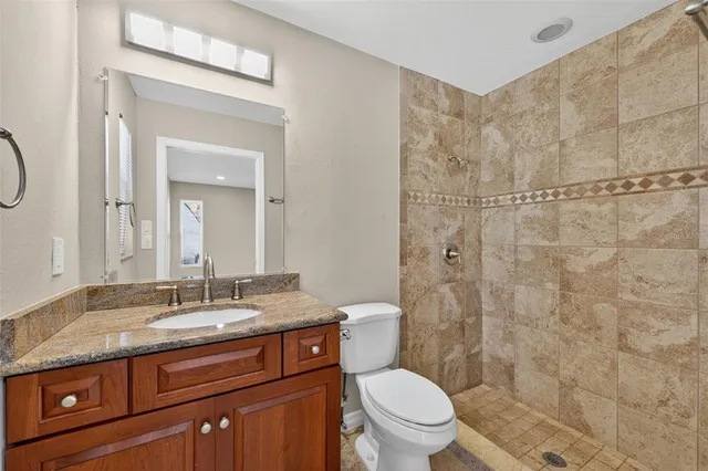 a bathroom with a granite countertop sink a toilet and a mirror