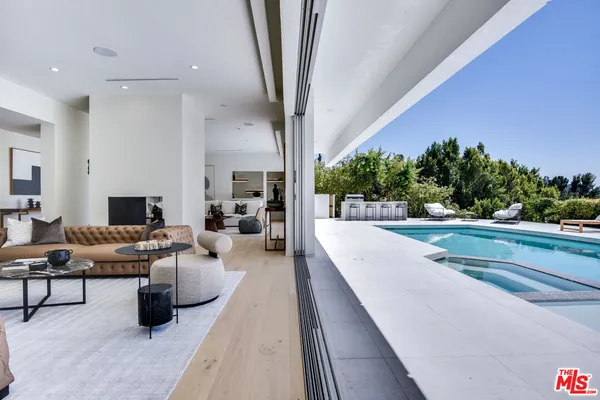 a living room with patio furniture and a potted plant