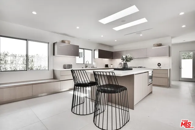 a kitchen with stainless steel appliances kitchen island granite countertop a stove a sink a dining table and chairs