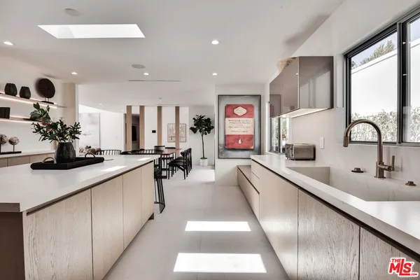 a large kitchen with kitchen island a large counter top space a sink and living room view