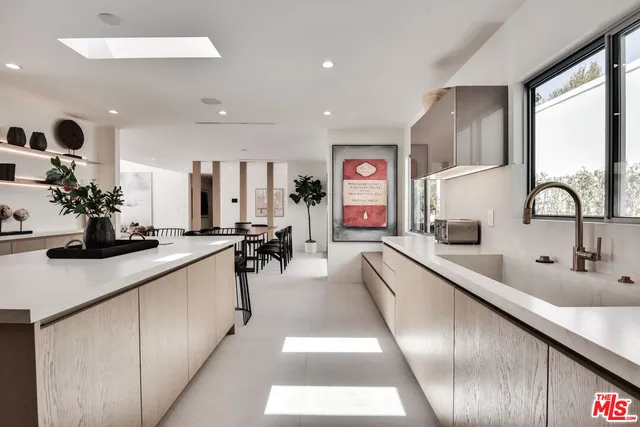 a large kitchen with kitchen island a large counter top space a sink and living room view