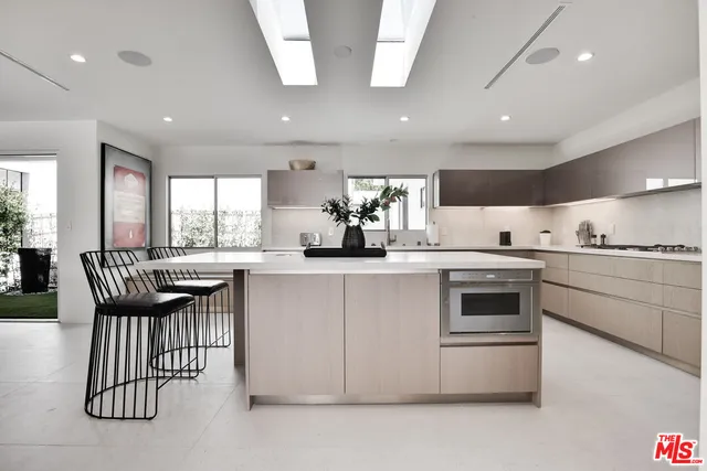 a kitchen with granite countertop white cabinets and stainless steel appliances