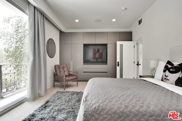 a bedroom with bed and a large window