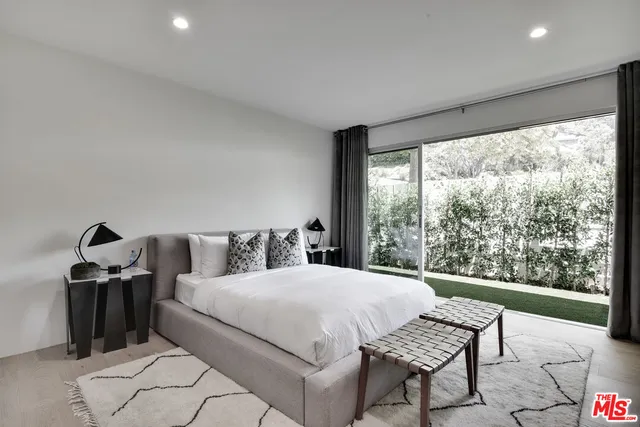 a bedroom with a bed and a large window