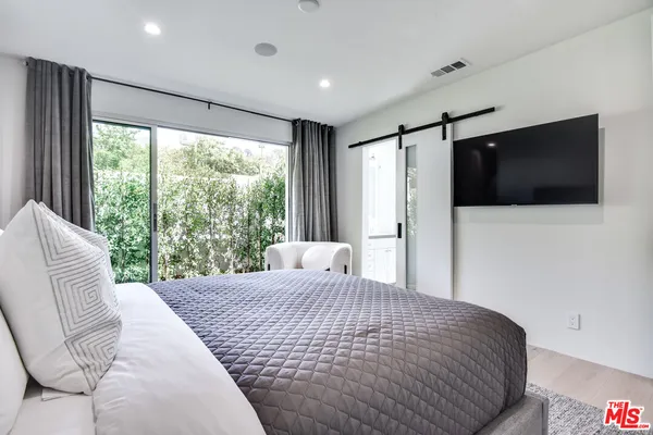 a bedroom with a large bed and a flat screen tv