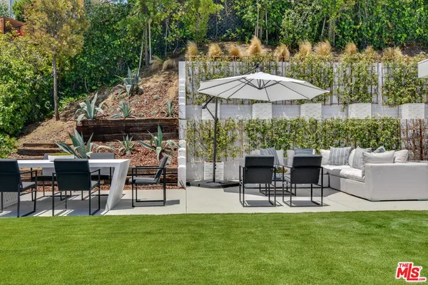 a view of a patio with a table and chairs under an umbrella