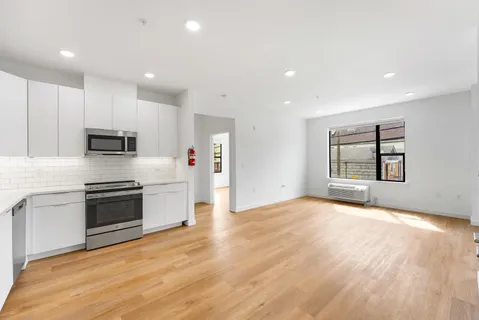 a large kitchen with stainless steel appliances granite countertop a stove a sink and a refrigerator