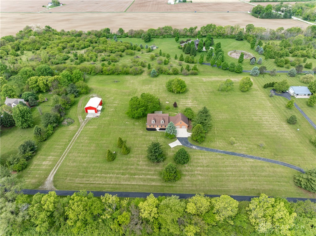 9981 Ridge Acres Lane Englewood, OH 45322 - Photo 49 of 73 This aerial view showcases a residential property nestled amidst lush greenery and open fields.